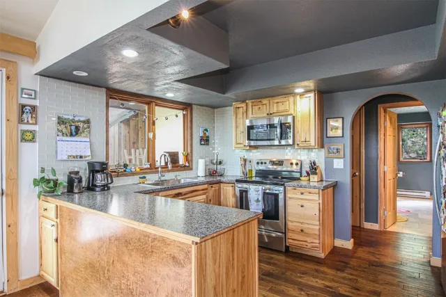 a kitchen with stainless steel appliances granite countertop a sink stove and cabinets