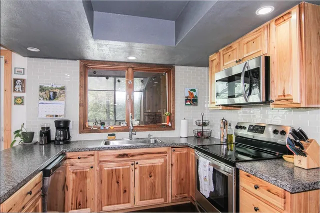 a kitchen with stainless steel appliances granite countertop a refrigerator and a sink