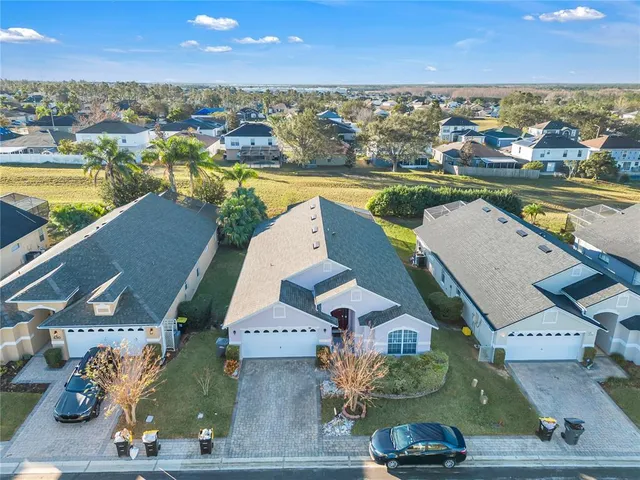 an aerial view of residential houses with outdoor space and ocean view