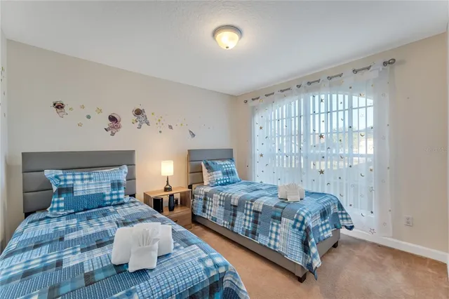 a bedroom with two beds and a chandelier