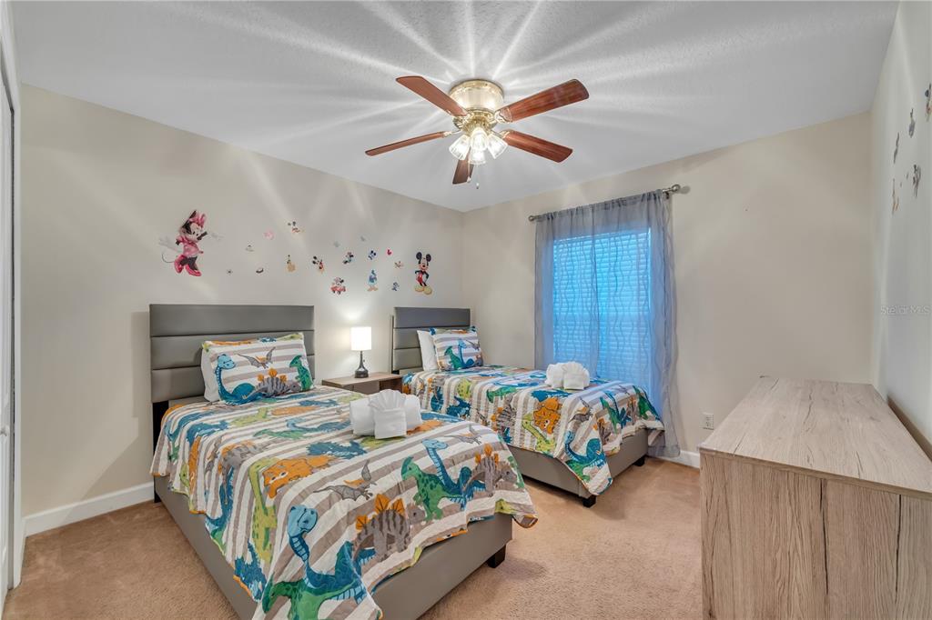 620 Old Bridge Circle Davenport, FL 33897 - Photo 14 of 22 a bedroom with two beds and a chandelier