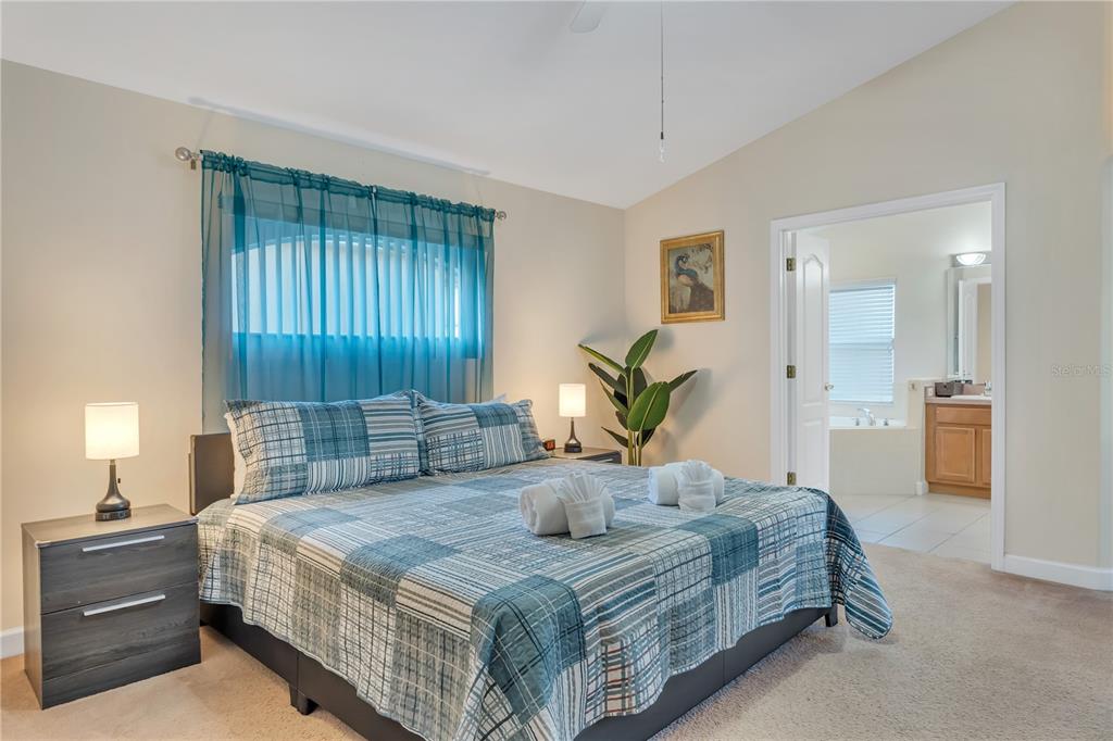 620 Old Bridge Circle Davenport, FL 33897 - Photo 9 of 22 a bedroom with a large bed and potted plant