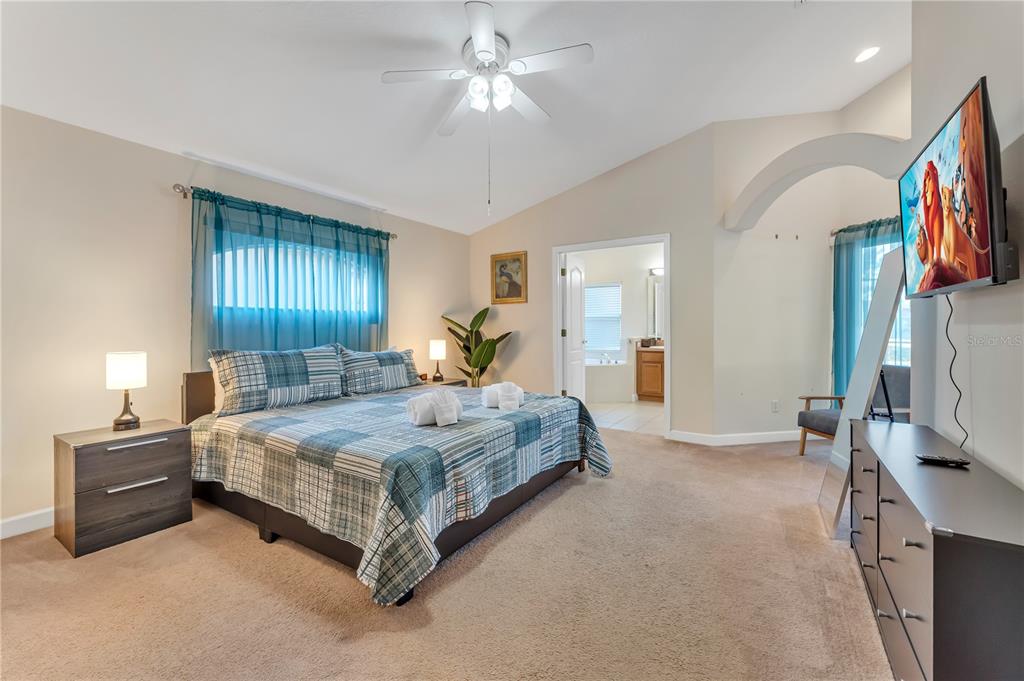 620 Old Bridge Circle Davenport, FL 33897 - Photo 10 of 22 a spacious bedroom with a bed and a chandelier