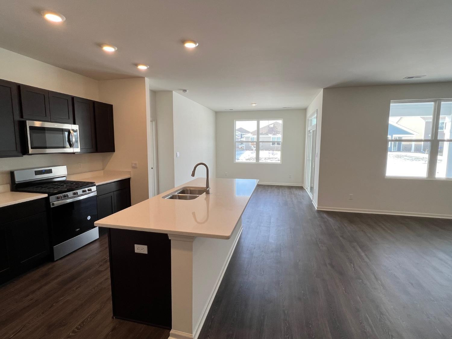 10400 Morse Place Crown Point, IN 46307 - Photo 2 of 33 a open kitchen with stainless steel appliances granite countertop a stove a sink dishwasher and a microwave oven with wooden floor