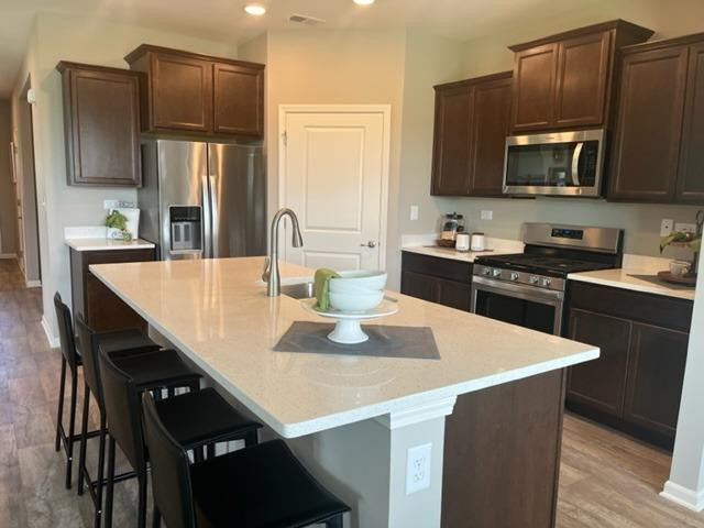 10400 Morse Place Crown Point, IN 46307 - Photo 23 of 33 a kitchen with stainless steel appliances a kitchen island hardwood floor sink and stove