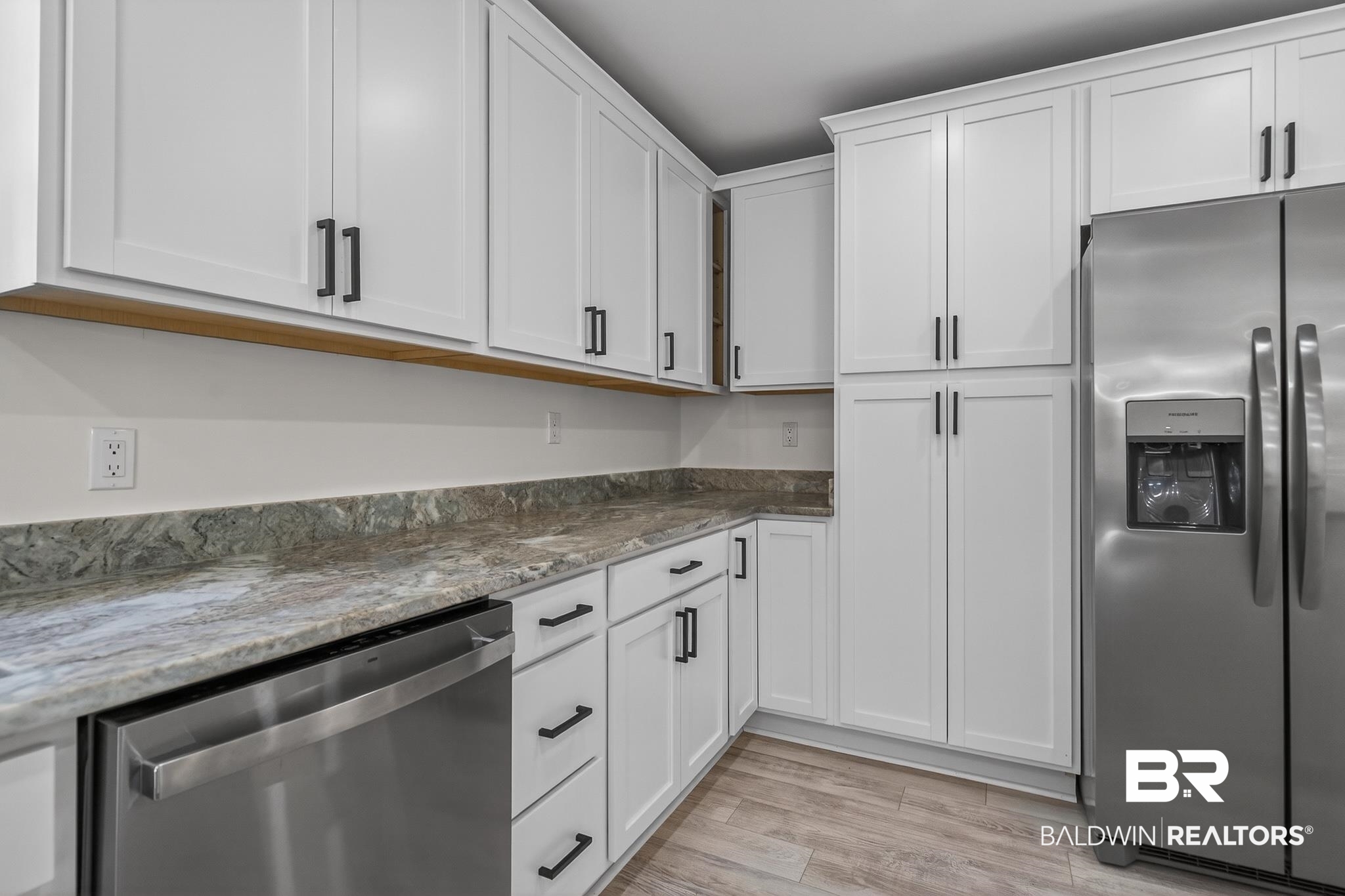 10650 Old Pascagoula Road Theodore, AL 36582 - Photo 22 of 77 Kitchen with stainless steel appliances, white cabinets, dark stone counters, and light wood finished floors