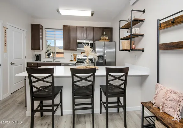a kitchen with a dining table chairs cabinets and stainless steel appliances