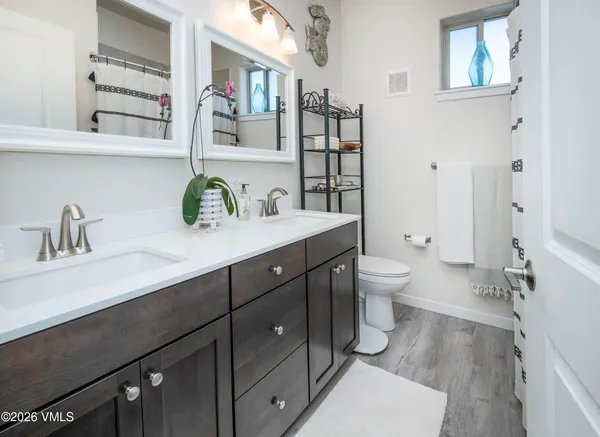 a spacious bathroom with a double vanity sink mirror and toilet
