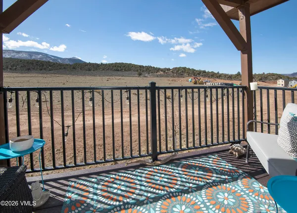 a view of a balcony with wooden floor and fence
