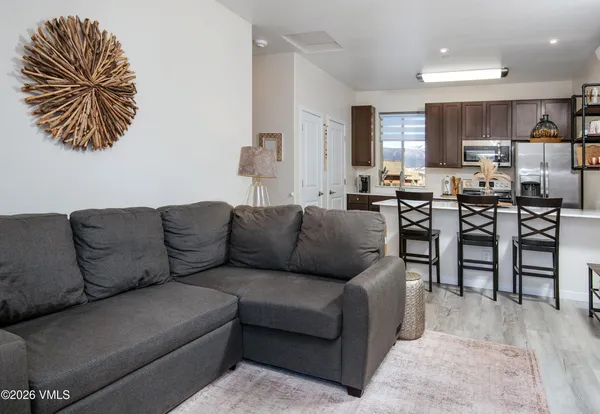 a living room with furniture kitchen and a table