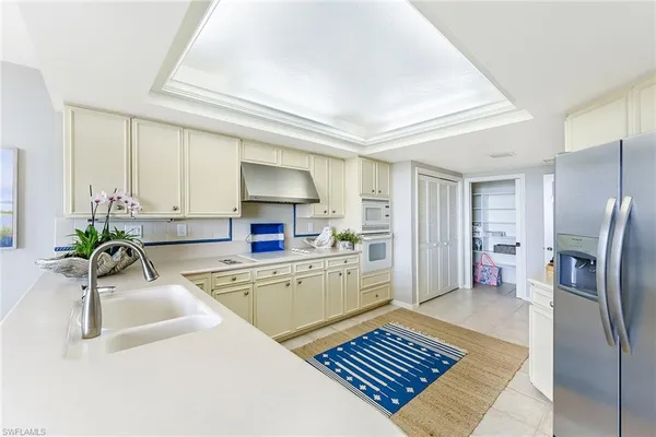 a kitchen with stainless steel appliances granite countertop a refrigerator a sink and a stove