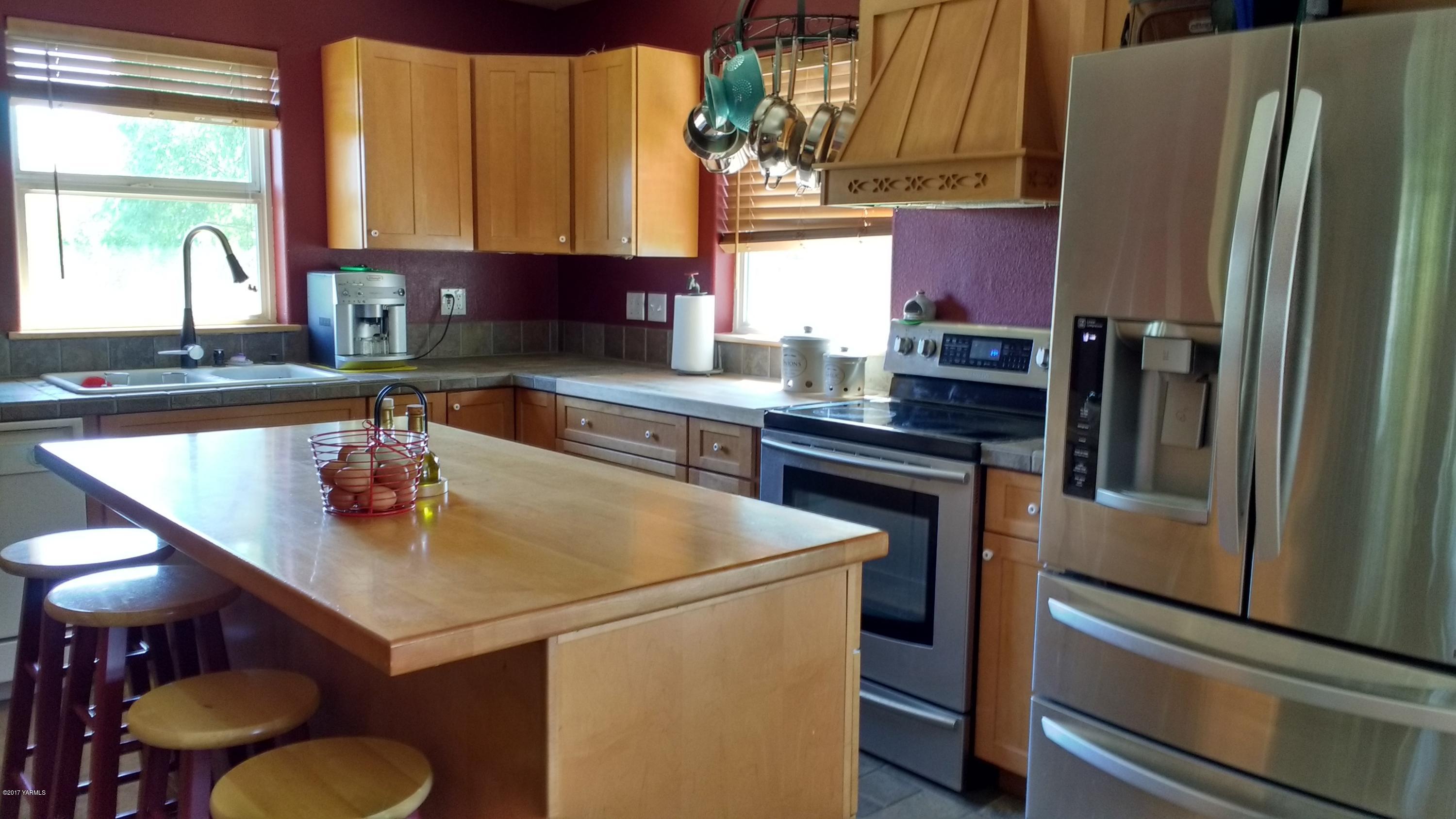 810 Red Tail Road Yakima, WA 98908 - Photo 9 of 42 a kitchen with stainless steel appliances granite countertop a sink a stove and a refrigerator