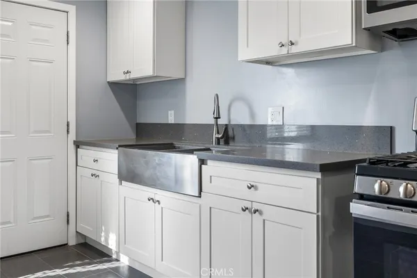 a kitchen with granite countertop white cabinets and a stove