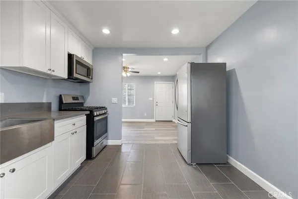 a kitchen with stainless steel appliances granite countertop a refrigerator and a stove top oven
