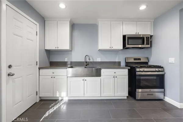 a kitchen with stainless steel appliances granite countertop a refrigerator and a stove top oven