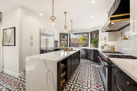 a kitchen with stainless steel appliances granite countertop a sink a stove and a refrigerator