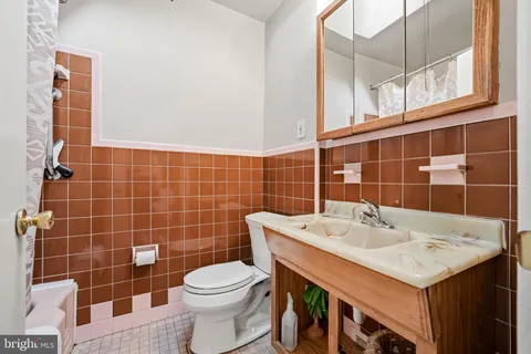 a bathroom with a sink toilet and mirror