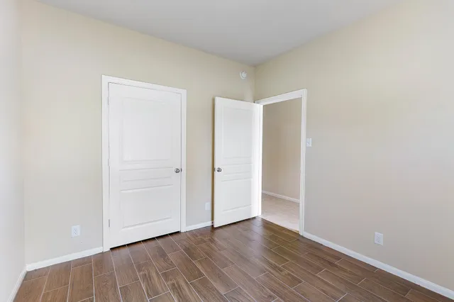 a view of an empty room with wooden floor