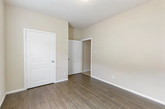 a view of an empty room with wooden floor