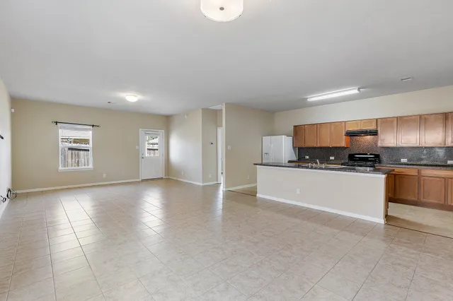 a view of kitchen with refrigerator sink and cabinets