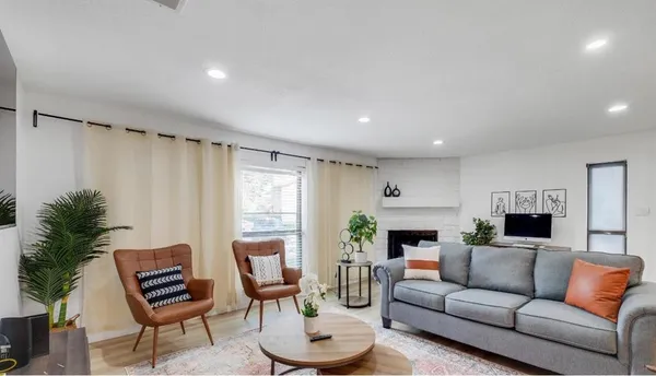 a living room with furniture a fireplace and a window