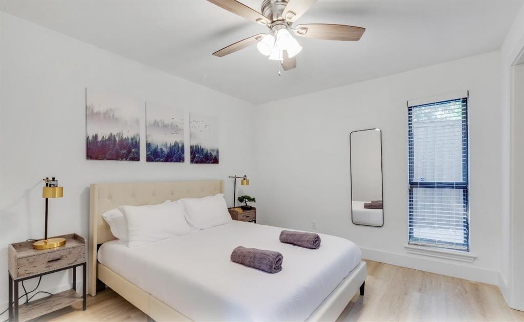 5041 Thunder Road Dallas, TX 75244 - Photo 12 of 20 a bedroom with a bed and a chandelier