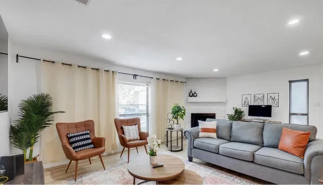 a living room with furniture a fireplace and a window