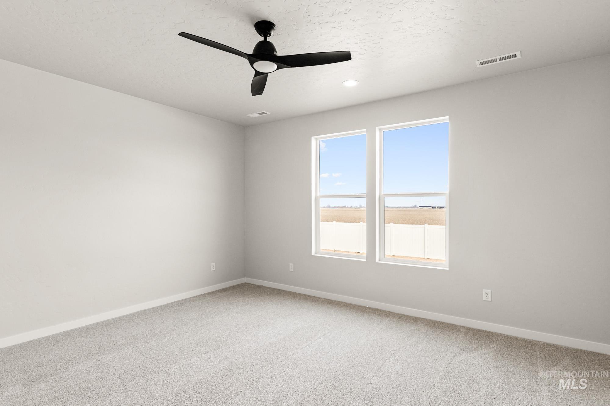 12865 Decatur Street Nampa, ID 83651 - Photo 16 of 20 Bedroom featuring two large windows, a ceiling-mounted fan with integrated lighting, recessed lighting, and grey carpeting