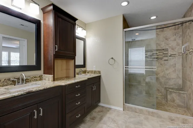 a bathroom with a granite countertop sink mirror and shower