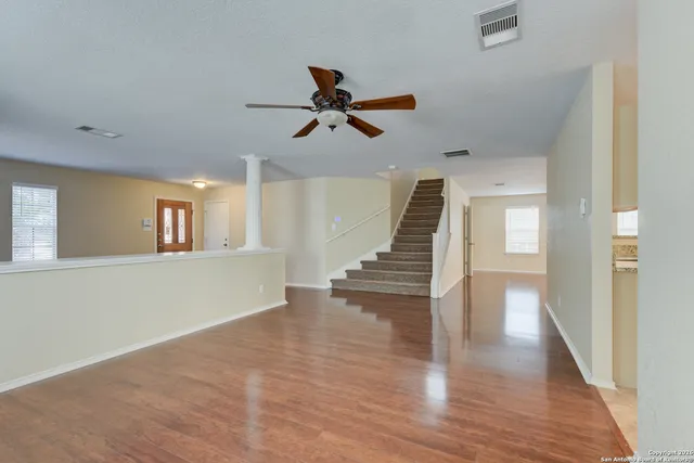 a view of an entryway with wooden floor and a ceiling fan