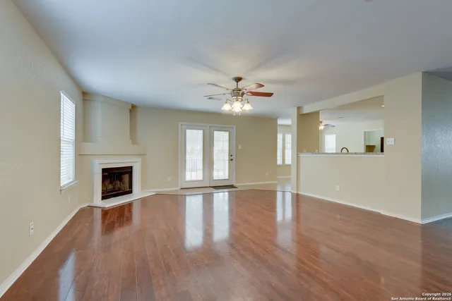 a view of an empty room with window and fire place
