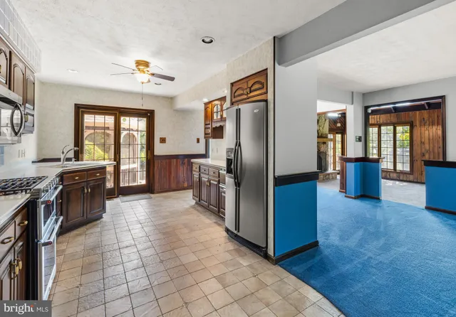 a large kitchen with stainless steel appliances granite countertop a refrigerator and a stove top oven