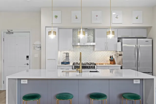 a kitchen with stainless steel appliances granite countertop a sink and white cabinets