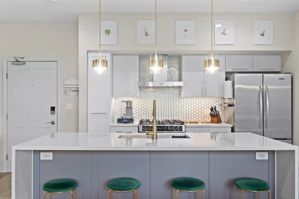 a kitchen with stainless steel appliances granite countertop a sink and white cabinets