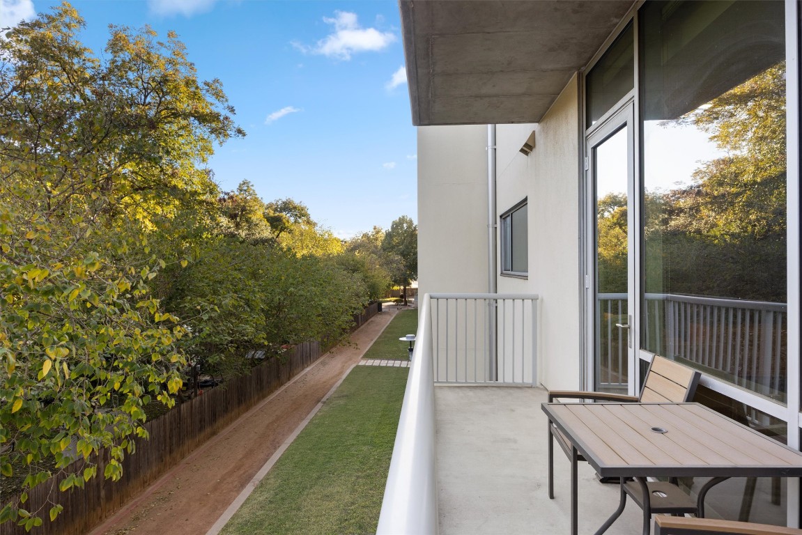 1600 Barton Springs Road, Unit 4205 Austin, TX 78704 - Photo 13 of 37 a view of a patio with table and chairs with wooden floor and fence