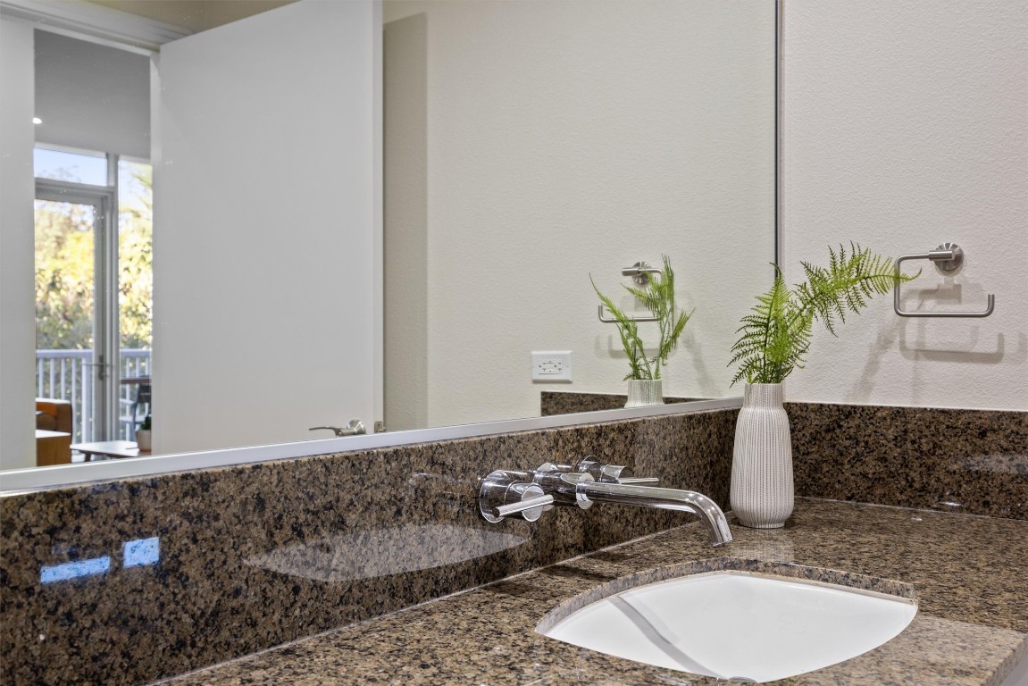 1600 Barton Springs Road, Unit 4205 Austin, TX 78704 - Photo 27 of 37 a bathroom with a granite countertop sink and a mirror