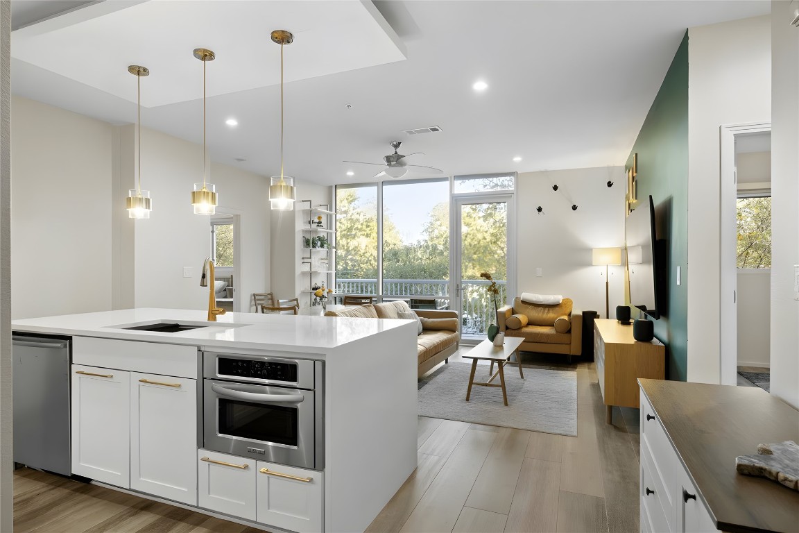 1600 Barton Springs Road, Unit 4205 Austin, TX 78704 - Photo 8 of 37 a open kitchen with stainless steel appliances granite countertop a stove and white cabinets with wooden floor