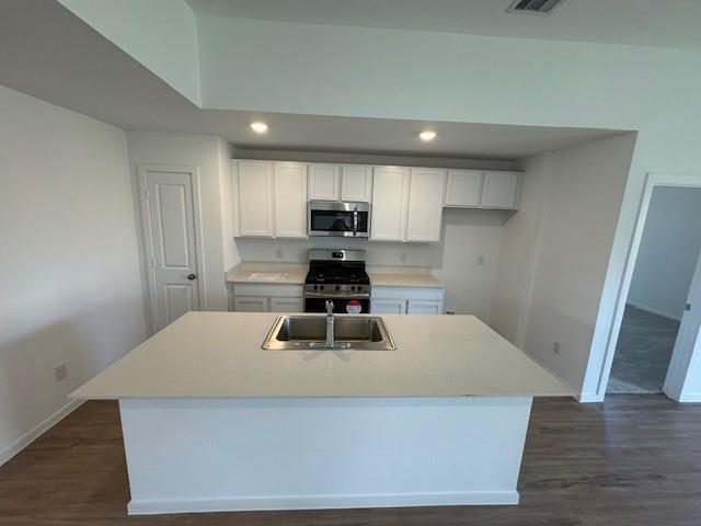 a kitchen with kitchen island a sink dishwasher a stove and a refrigerator with wooden floor