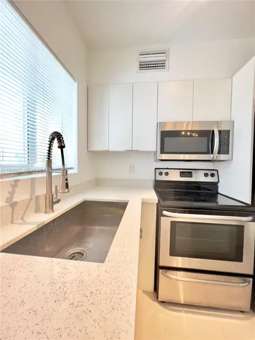 a kitchen with granite countertop a stove and a sink