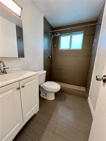 a bathroom with a sink a toilet a shower and a mirror