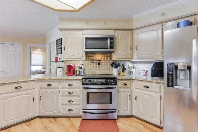 a kitchen with white cabinets and stainless steel appliances