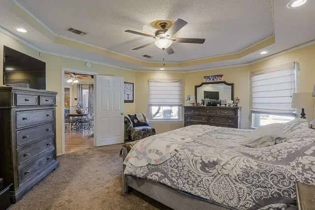 a spacious bedroom with a bed and a flat screen television