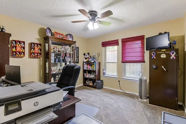a view of a workspace with furniture and a window