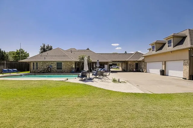 a view of a house with swimming pool and a yard