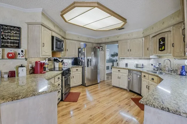 a kitchen with a sink stove top oven and refrigerator