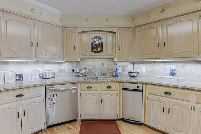 a kitchen with granite countertop white cabinets and sink