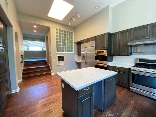 a kitchen with a refrigerator and a stove top oven