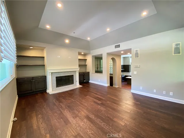 a view of a livingroom with a fireplace a ceiling fan and window