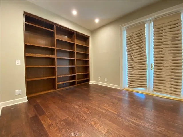 a view of an empty room with a window and a chair