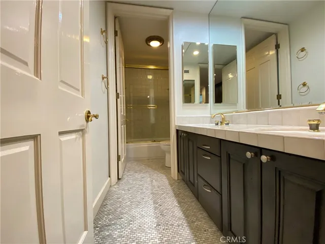 a spacious bathroom with a shower sink and mirror